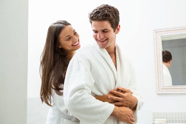 Feliz pareja abrazándose en el baño