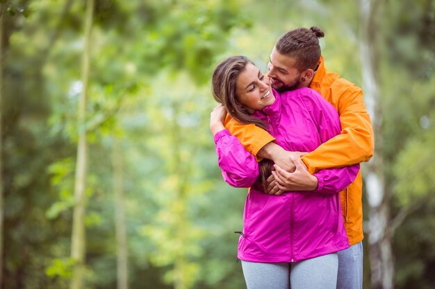 Feliz pareja abrazándose en caminata