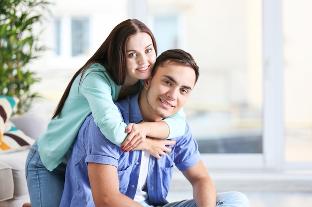 Feliz pareja abrazándose en casa