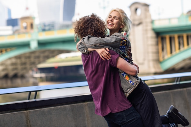 Feliz pareja abrazándose cerca del puente de Southwark sobre el río Támesis, Londres