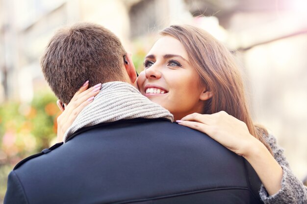 feliz pareja abrazándose en la ciudad