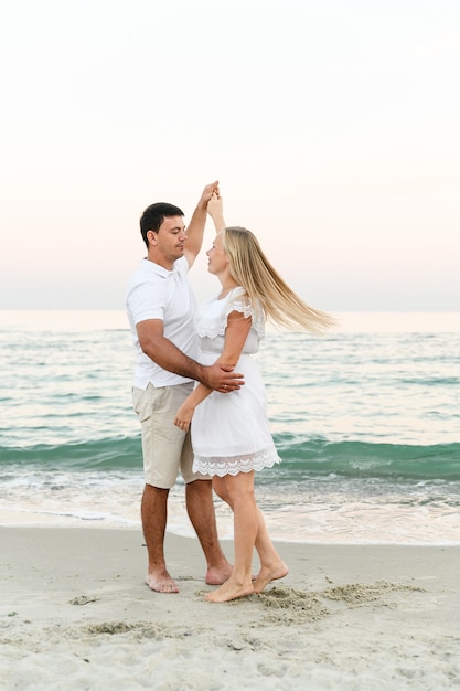 Feliz pareja abrazándose a la orilla del mar. tiempo romántico. jóvenes felices.