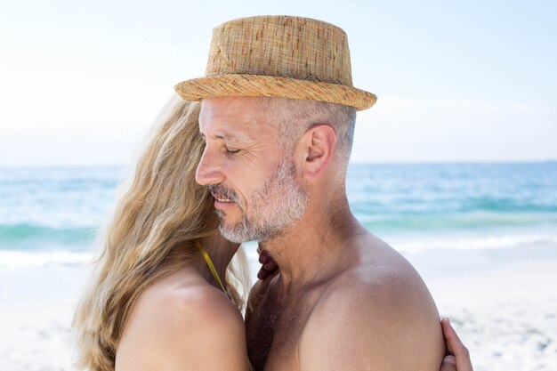 Feliz pareja abrazándose unos a otros junto al mar