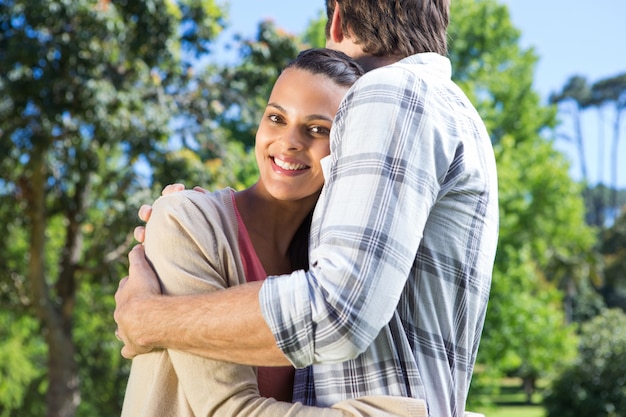 Feliz pareja abrazándose en el parque