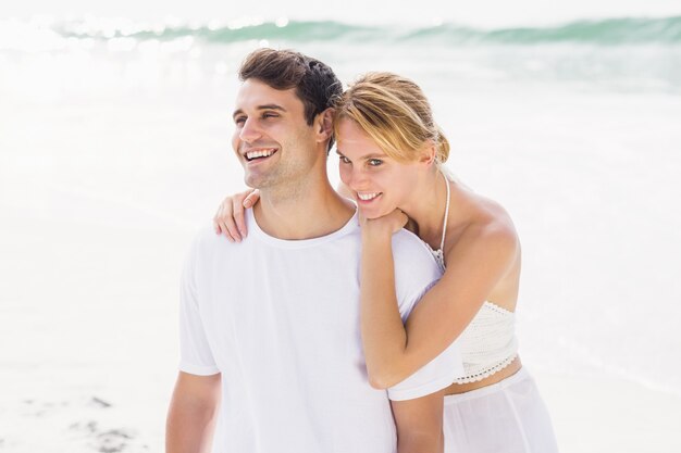 Feliz pareja abrazándose en la playa