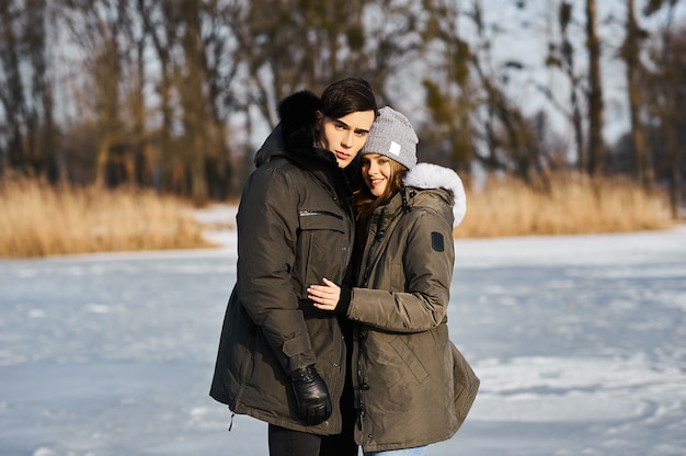 Feliz pareja abrazándose y riendo al aire libre en invierno.