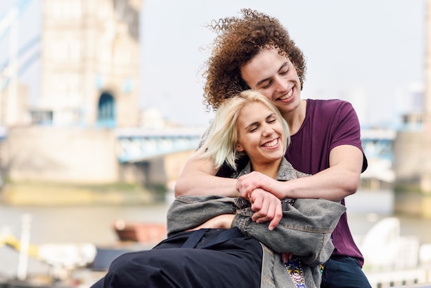 Feliz pareja abrazándose en el Tower Bridge