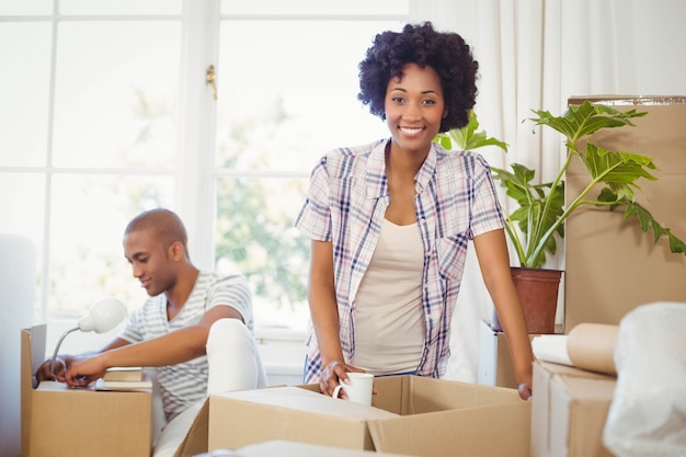 Feliz pareja abriendo cajas en la sala de estar