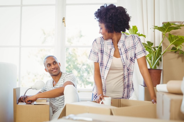 Feliz pareja abriendo cajas en la sala de estar