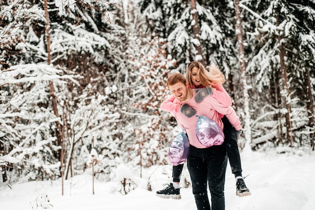 Feliz pareja activa en el bosque de invierno, día de moroz, estilo de vida.