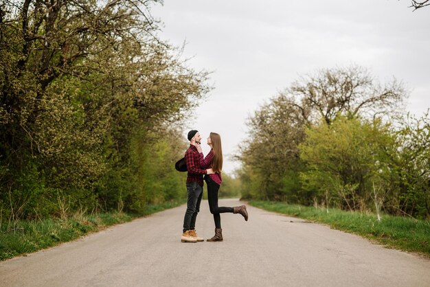 Feliz pareja activa caminando y diviértete en la carretera del campo