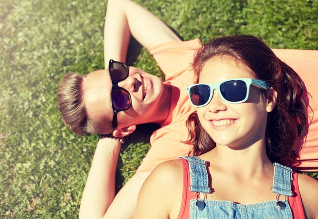 Foto una feliz pareja adolescente acostada en la hierba en verano