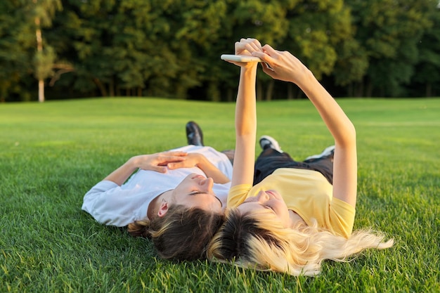 Feliz pareja de adolescentes sobre hierba verde