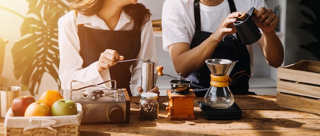 Feliz pareja de adultos jóvenes preparando el desayuno y tomando café juntos en la acogedora cocina de la casa por la mañana en casa preparando comida y sonriendo Estilo de vida ocio y concepto de amor