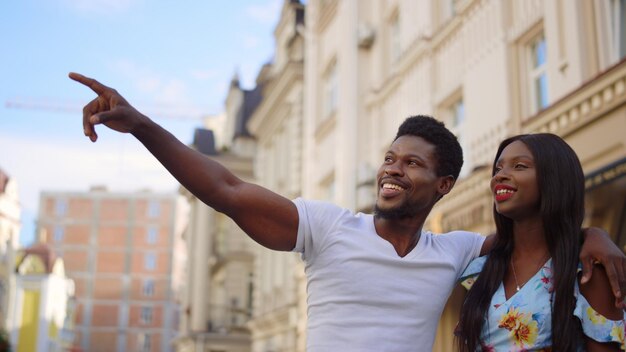 Feliz pareja africana abrazándose en la calle Chica y chico pasando tiempo en una cita al aire libre