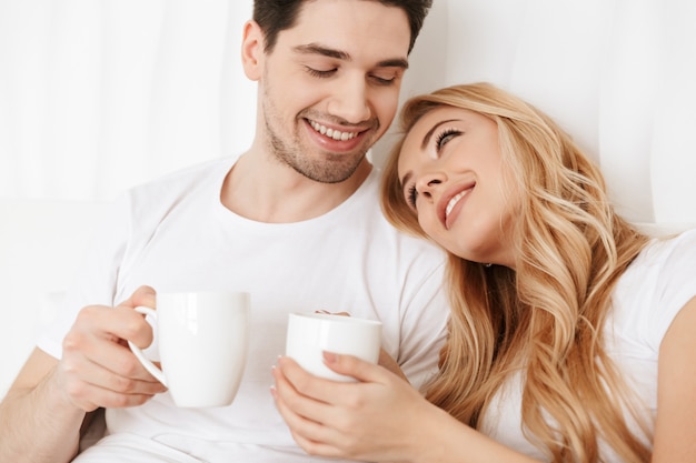 Feliz pareja amorosa en la cama en el interior en casa