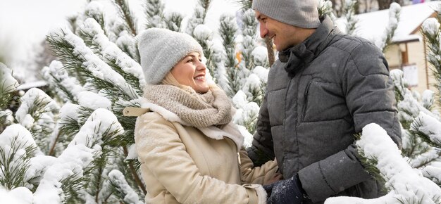 feliz pareja amorosa caminando en el bosque nevado de invierno, pasando las vacaciones de Navidad juntos. Actividades de temporada al aire libre. Captura de estilo de vida.