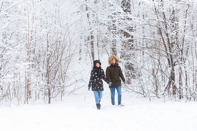 Feliz pareja amorosa divirtiéndose al aire libre en el parque de nieve. Vacaciones de invierno.