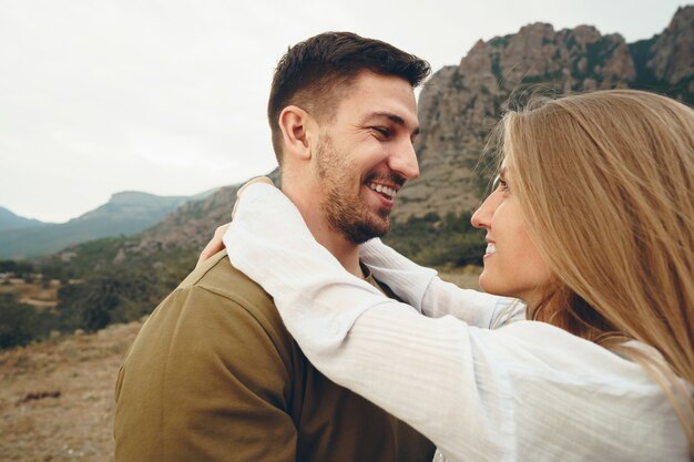 Feliz pareja amorosa senderismo y abrazos en las montañas