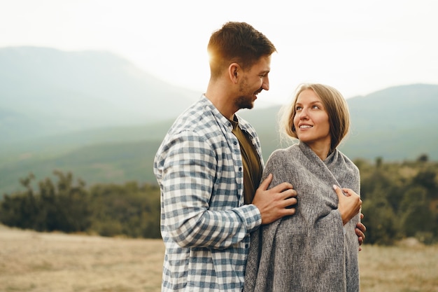 Feliz pareja amorosa senderismo y abrazos en las montañas