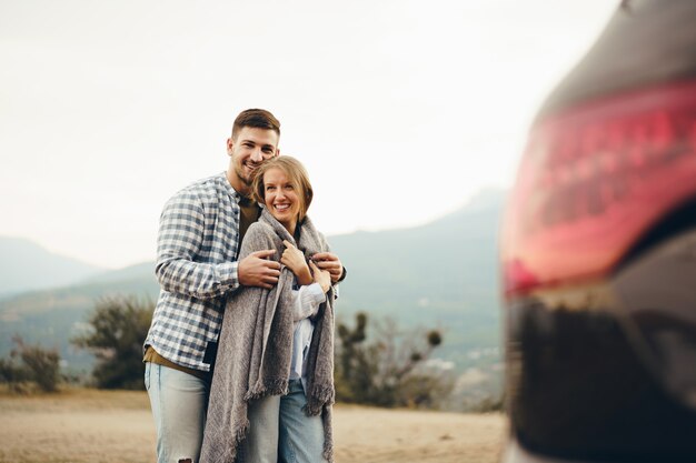 Feliz pareja amorosa senderismo y abrazos en las montañas