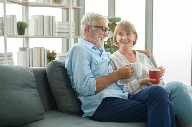Feliz pareja de ancianos caucásicos está bebiendo café en casa, relajante y concepto de atención médica.
