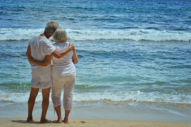 Foto feliz pareja de ancianos descansa en la playa tropical