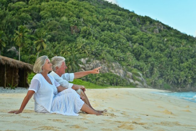 Feliz pareja de ancianos descansa en la playa tropical