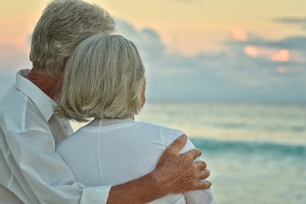 Feliz pareja de ancianos descansa en la playa tropical