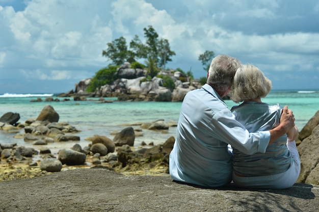 Feliz pareja de ancianos descansa en la playa tropical