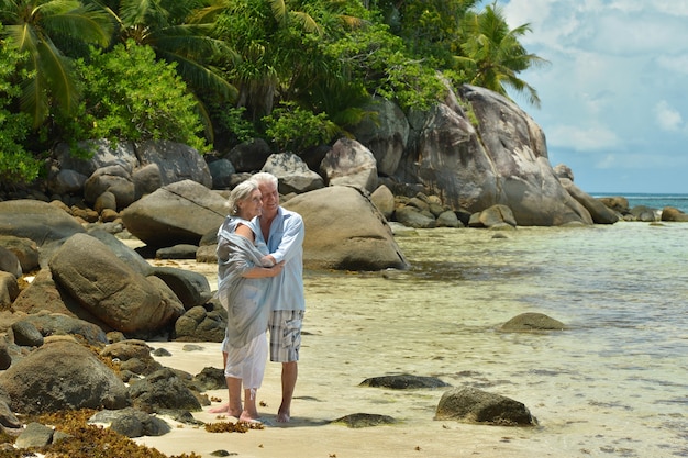 Feliz pareja de ancianos descansa en la playa tropical