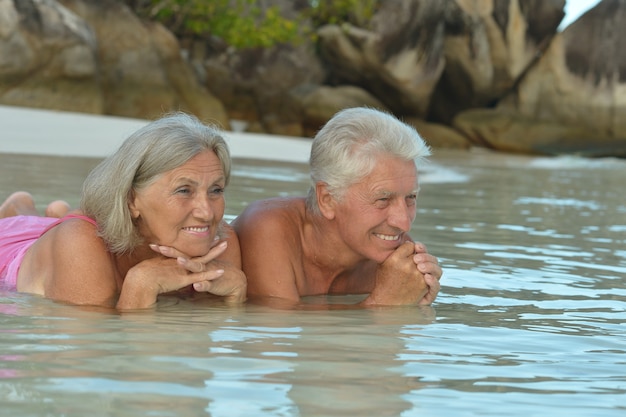 Feliz pareja de ancianos descansa en la playa tropical