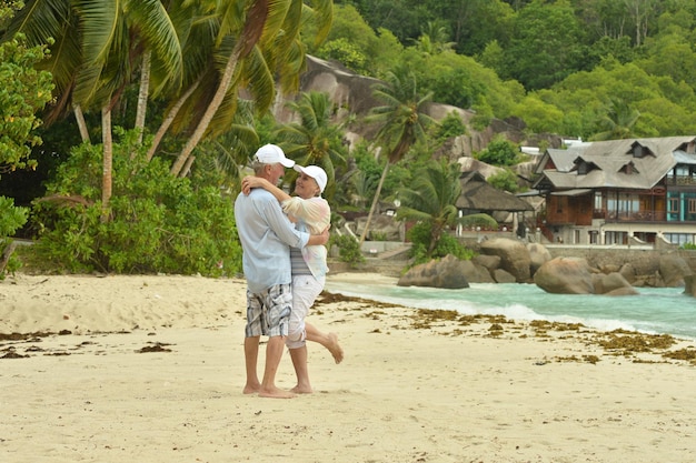 Feliz pareja de ancianos descansando en el jardín tropical al aire libre