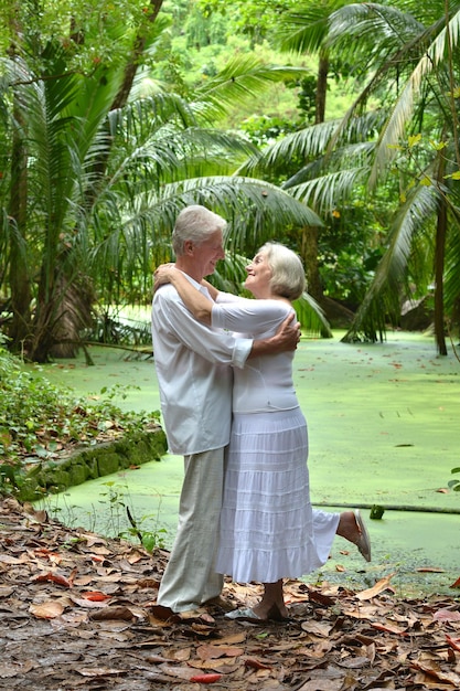 Feliz pareja de ancianos descansando en la playa tropical