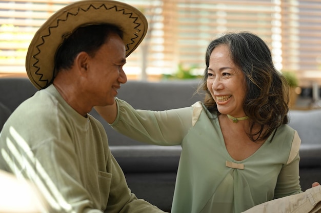 Feliz pareja de ancianos empacando tela y cosas preparándose para las vacaciones de verano Viajando en concepto de jubilación