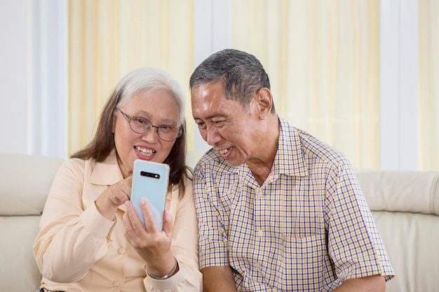 Feliz pareja de ancianos haciendo una videollamada