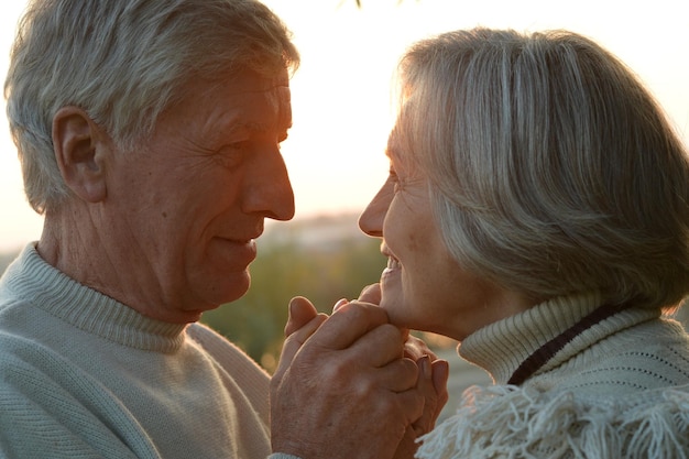 Feliz pareja de ancianos en la hermosa puesta de sol