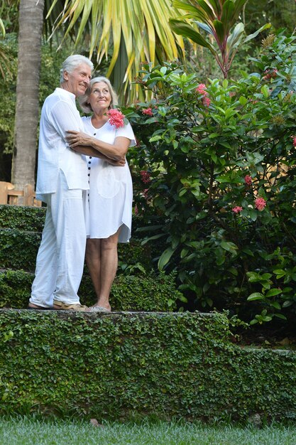 Feliz pareja de ancianos en el jardín tropical al aire libre