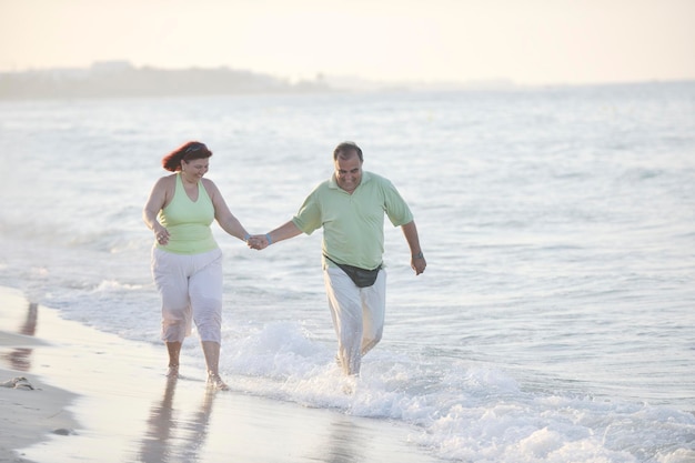 feliz pareja de ancianos maduros tienen tiempo romántico en la playa al atardecer