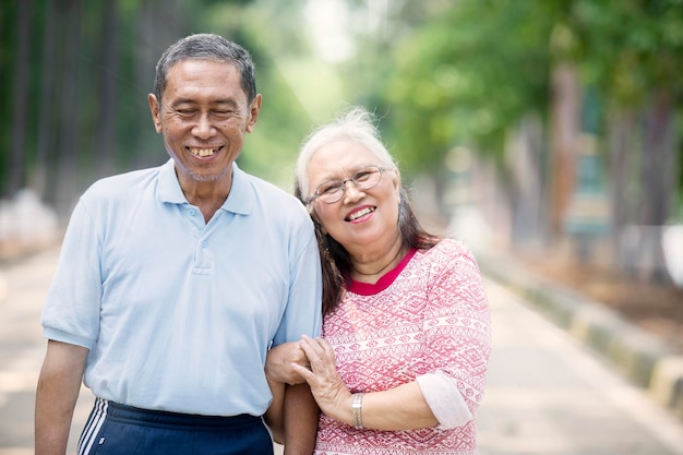 Feliz pareja de ancianos de pie en el parque