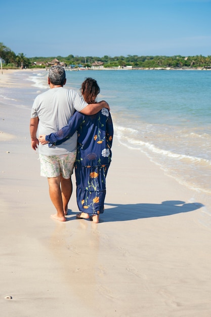 Feliz pareja de ancianos de pie en una playa