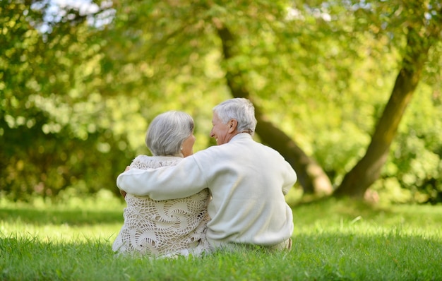 Feliz pareja de ancianos sentados en el parque otoño