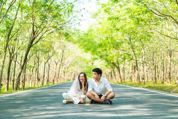 Feliz pareja asiática en el amor en el camino con arco de árbol