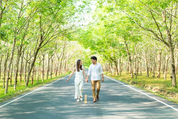 Feliz pareja asiática en el amor en el camino con arco de árbol