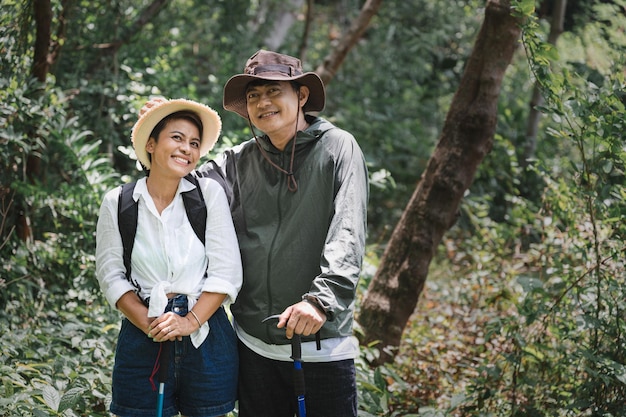 Feliz pareja asiática caminando en el bosque