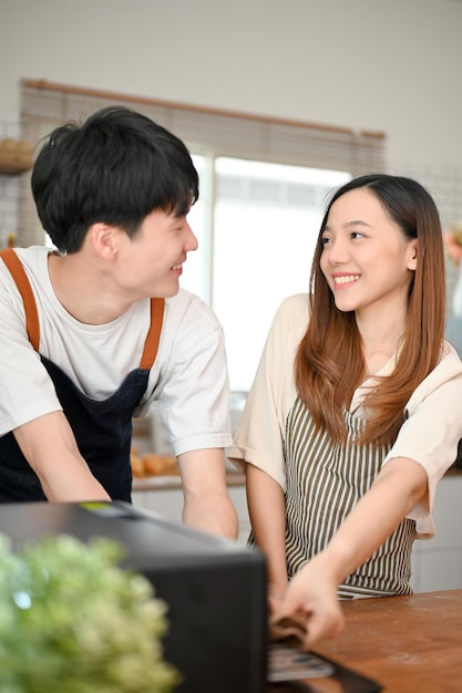 Feliz pareja asiática disfruta horneando en la cocina juntos divirtiéndose juntos en casa