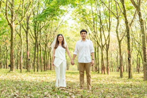 Feliz pareja asiática enamorada del arco del árbol