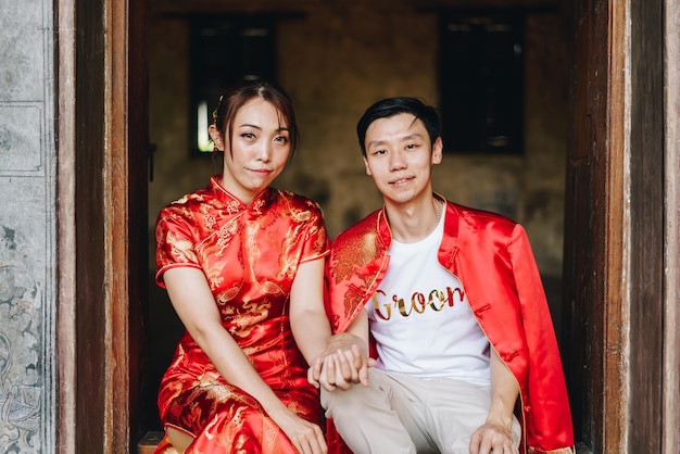 Feliz pareja asiática joven amor en vestidos tradicionales chinos - El rojo es el color principal de la fiesta tradicional que incluye la boda en China.