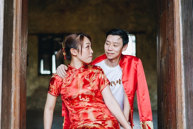 Feliz pareja asiática joven amor en vestidos tradicionales chinos - El rojo es el color principal de la fiesta tradicional que incluye la boda en China.