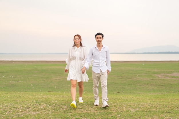 Feliz pareja asiática joven en ropa de novia y novio
